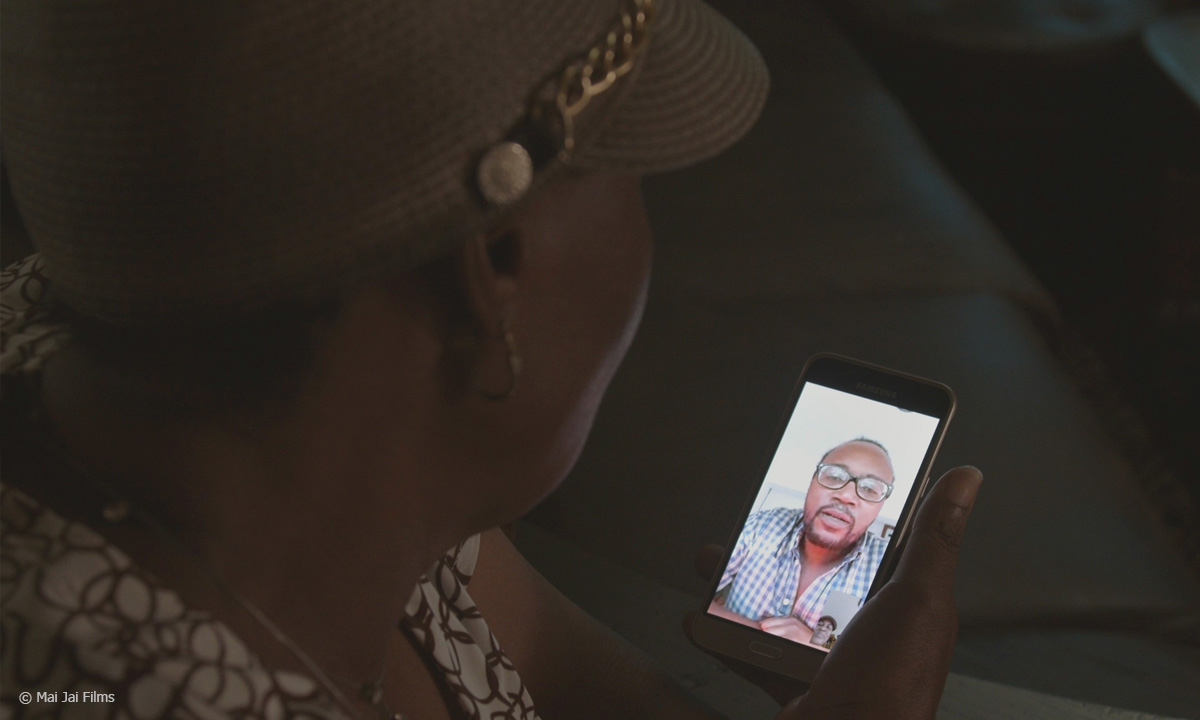 Filmstill "Geld für Mutter nach Simbabwe": Miles, Portia und Noma (v.l.) bei einem Videoanruf,  Filmstill "Geld für Mutter nach Simbabwe": rank spricht per Videoanruf mit seiner Mutter in Simbabwe, © Mai Jai Films