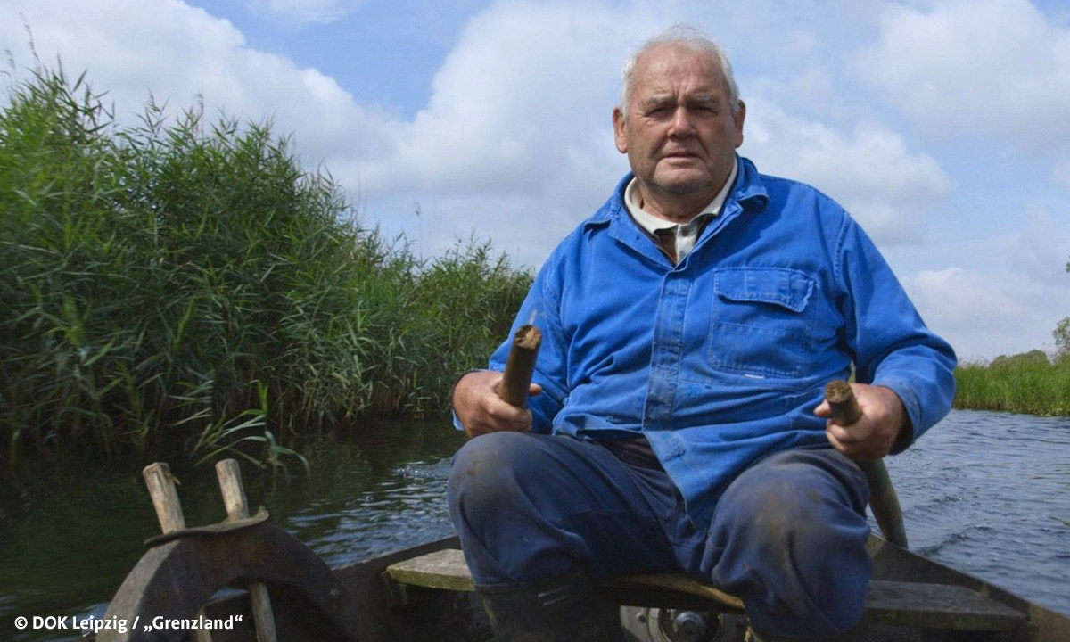 Filmstill "Grenzland", abgebildet ist ein älterer Mann in einem Ruderboot