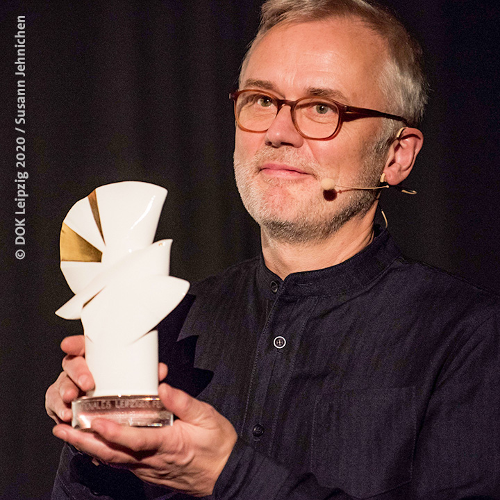 Bild: Festivallleiter Christoph Terhechte hält Goldene Taube beim DOK Leipzig