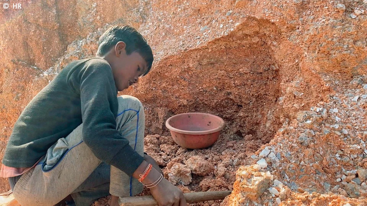 Ein Junge arbeitet in einem Steinbruch