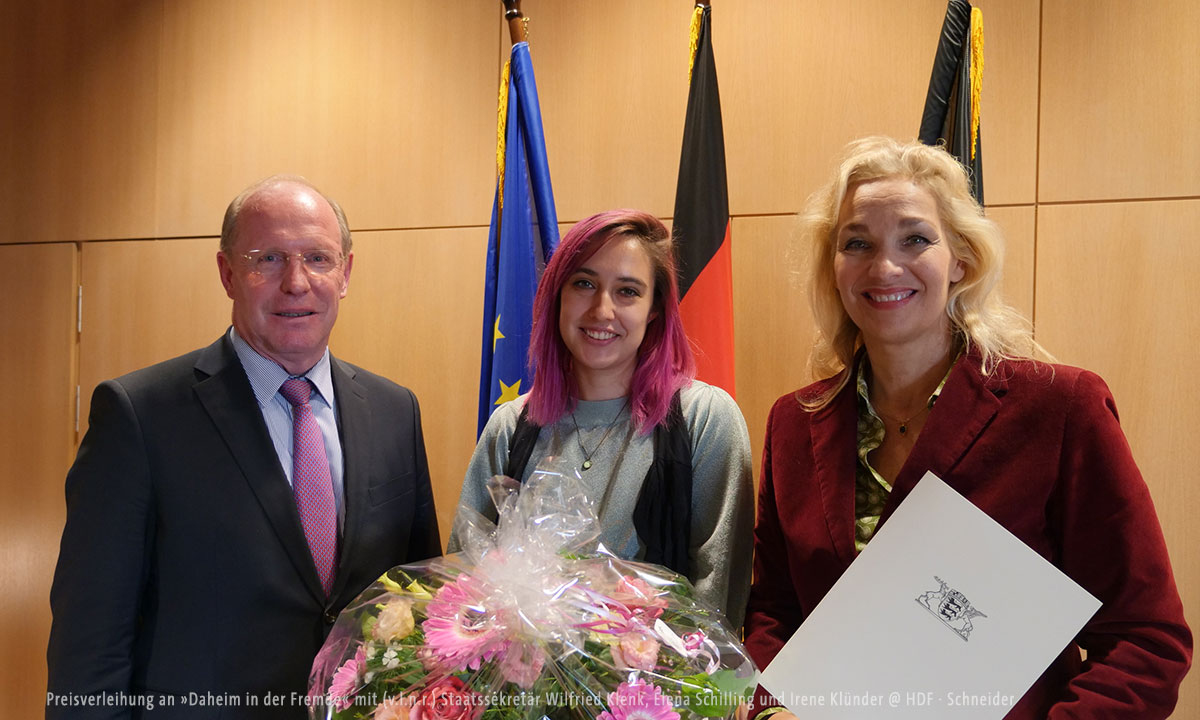 Preisverleihung an »Daheim in der Fremde« mit (v.l.n.r.) Staatssekretär Wilfried Klenk, Elena Schilling und Irene Klünder © HDF · Schneider